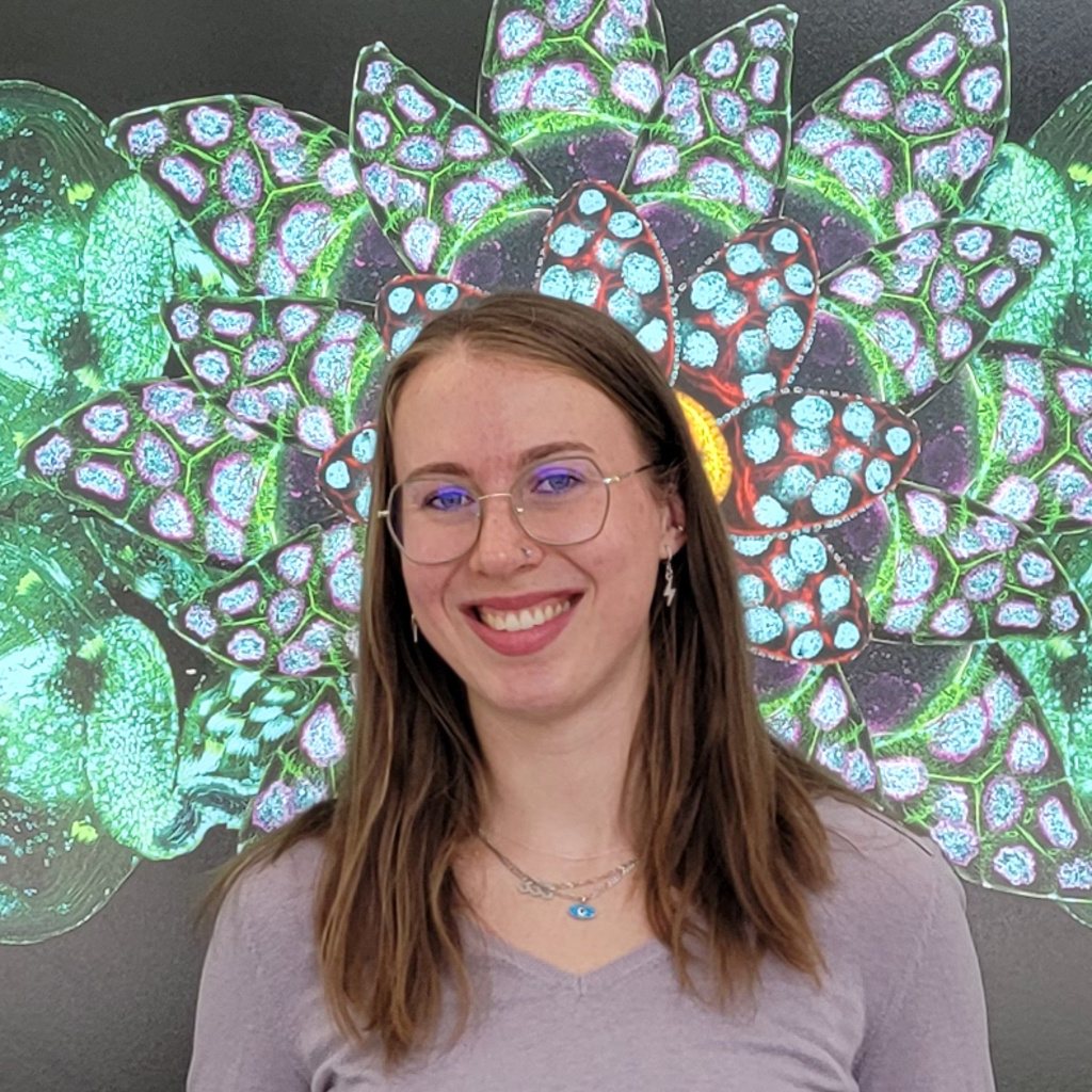 Anneke Kanuss standing in front of a poster-sized image of a biological specimen