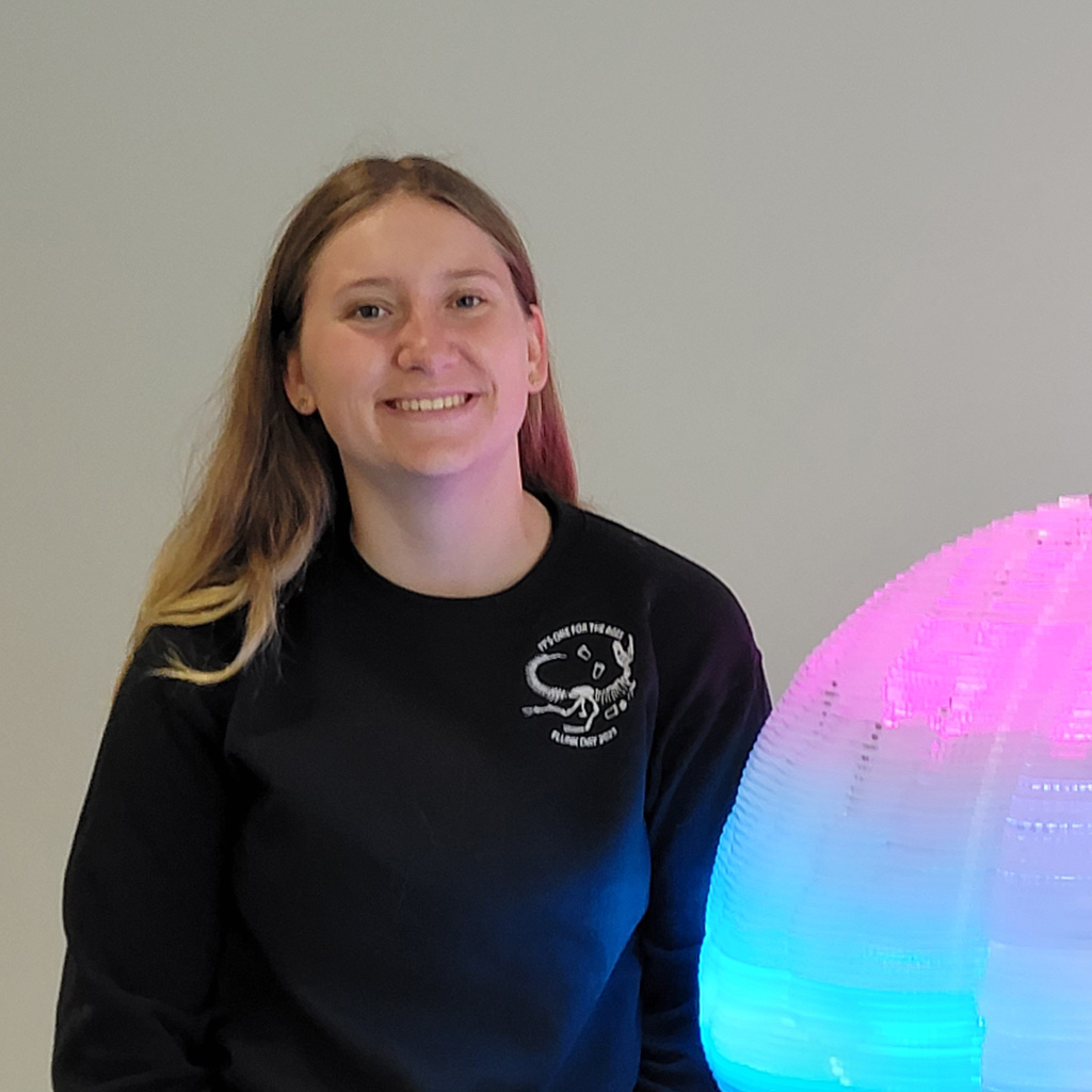 Photo of Hannah Brunner in front of a lighted brain sculpture